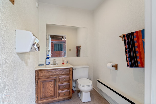 bathroom with large vanity, a baseboard radiator, and toilet