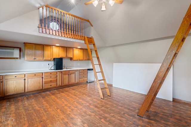 kitchen with dark hardwood / wood-style flooring, dishwasher, ceiling fan, a wall unit AC, and a high ceiling