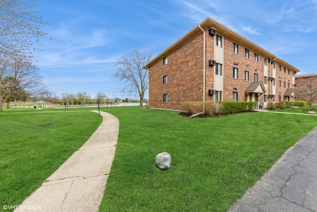 view of side of home with brick siding and a lawn