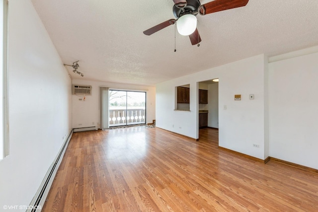 empty room with ceiling fan, a baseboard heating unit, a textured ceiling, and light wood-style flooring