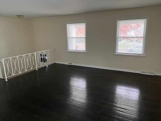 unfurnished room with dark wood-type flooring and a wealth of natural light