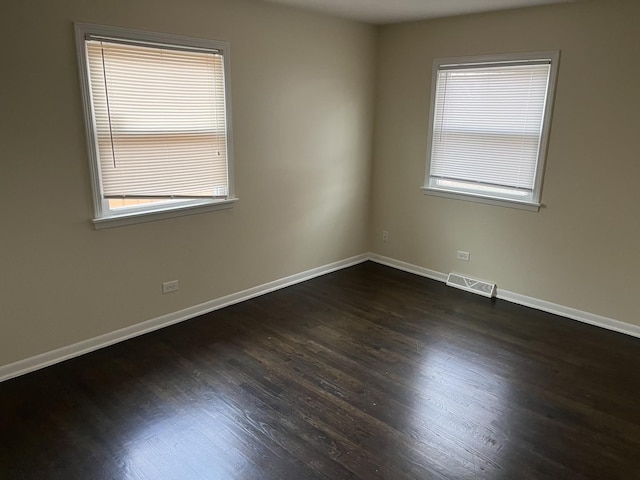 empty room with dark hardwood / wood-style flooring