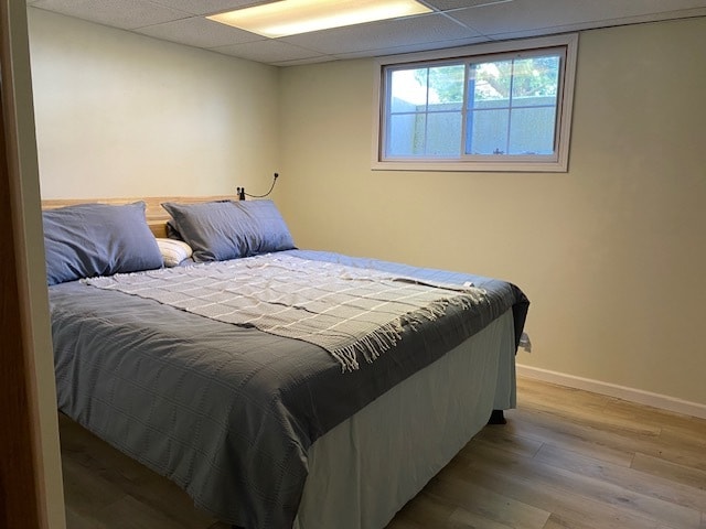 bedroom featuring wood-type flooring and a paneled ceiling