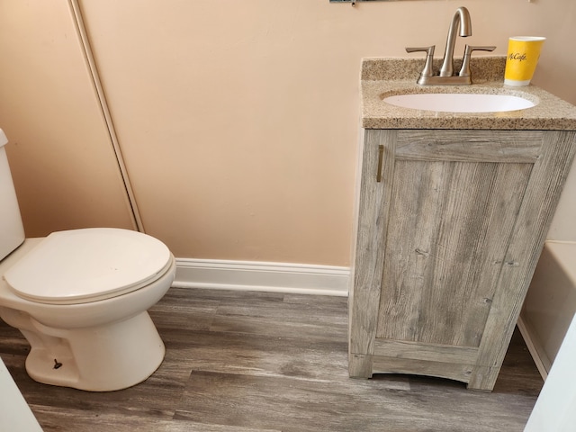 bathroom featuring toilet, vanity, and hardwood / wood-style flooring