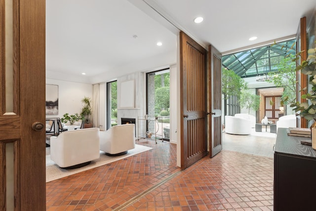 interior space featuring recessed lighting, a lit fireplace, and expansive windows