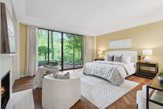 bedroom featuring a fireplace with flush hearth and access to exterior