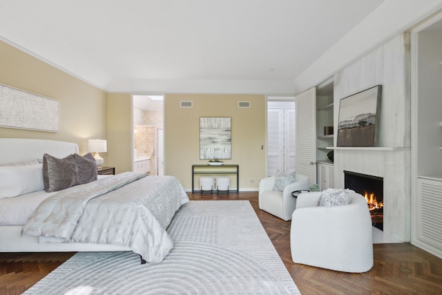 bedroom featuring parquet flooring and a large fireplace