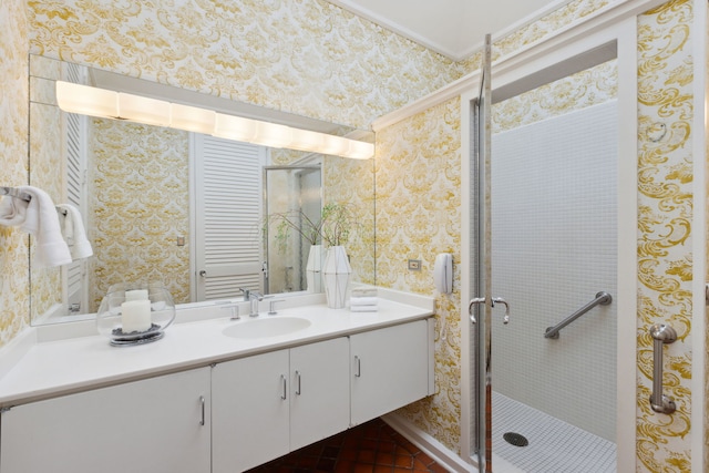 full bath with wallpapered walls, a stall shower, and vanity