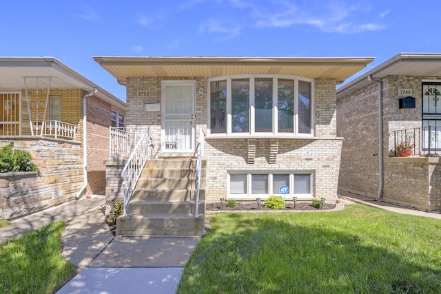 view of front facade with a front yard and brick siding