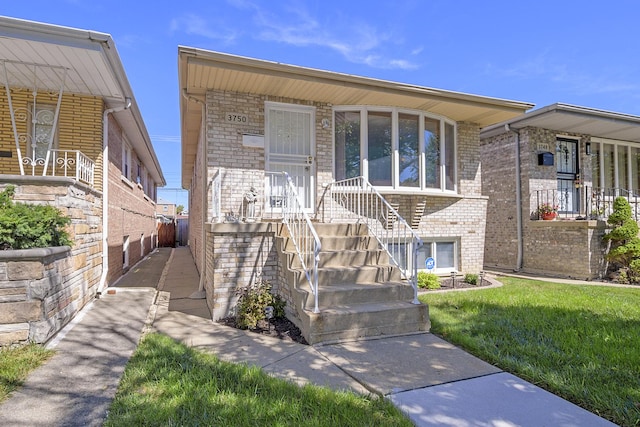 view of front of home featuring brick siding and a front lawn