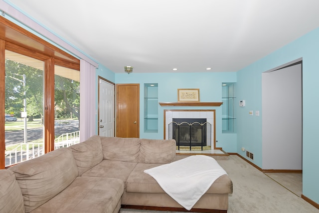 carpeted living room featuring a tile fireplace