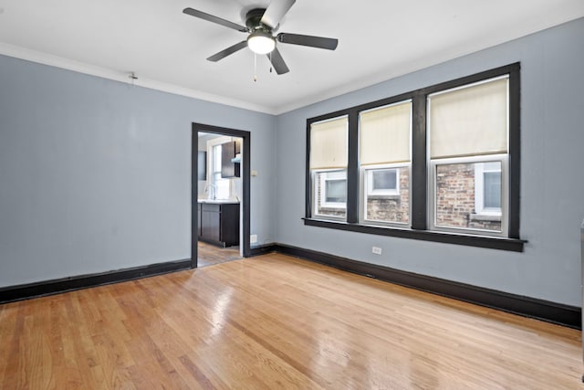 unfurnished room with a healthy amount of sunlight, crown molding, ceiling fan, and light wood-type flooring