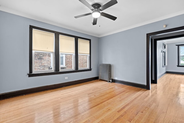 unfurnished room featuring ornamental molding, ceiling fan, light hardwood / wood-style floors, and radiator heating unit