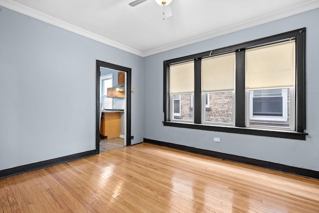 empty room featuring a healthy amount of sunlight, ceiling fan, and light wood-type flooring