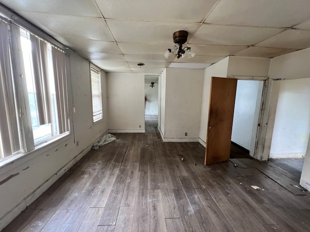 unfurnished bedroom featuring dark wood-type flooring and a drop ceiling