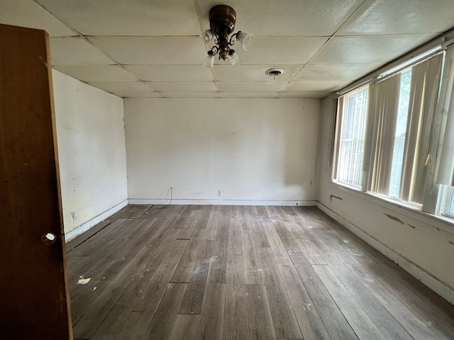 spare room with hardwood / wood-style floors and a drop ceiling