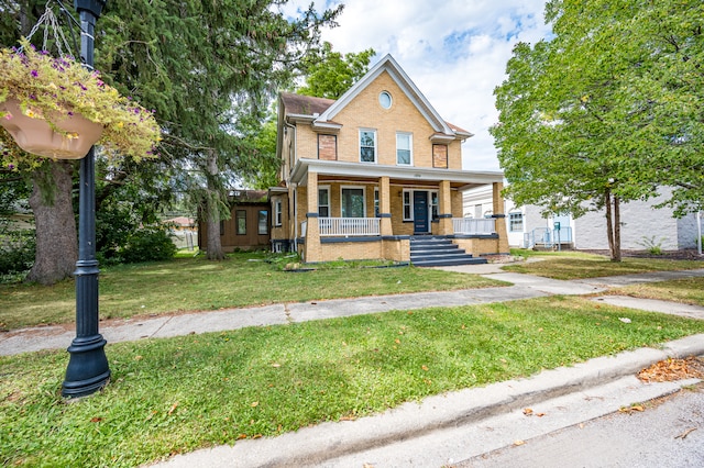 view of front facade featuring covered porch and a front yard