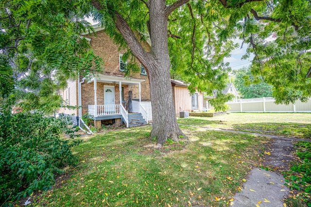 obstructed view of property featuring central air condition unit and a front lawn