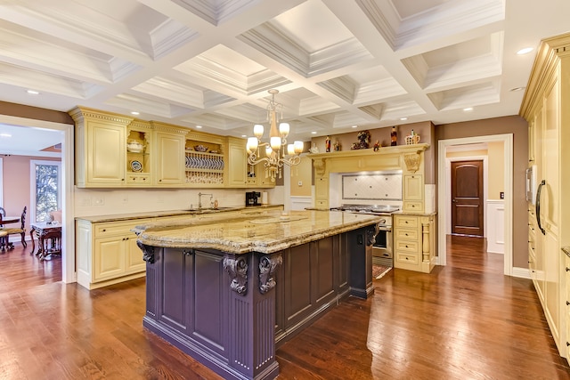 kitchen featuring light stone countertops, coffered ceiling, an inviting chandelier, a center island, and tasteful backsplash