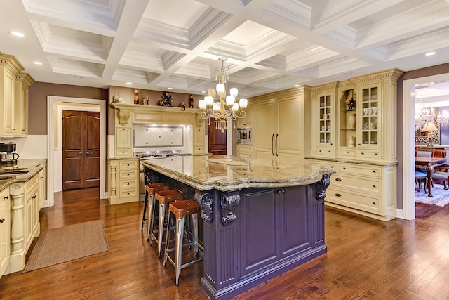 kitchen with a notable chandelier, backsplash, a center island with sink, and a kitchen breakfast bar