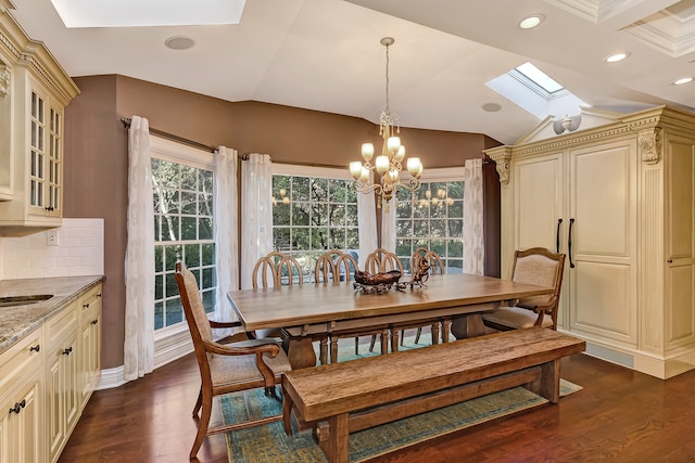 dining area with lofted ceiling with skylight, a notable chandelier, dark wood-type flooring, and coffered ceiling