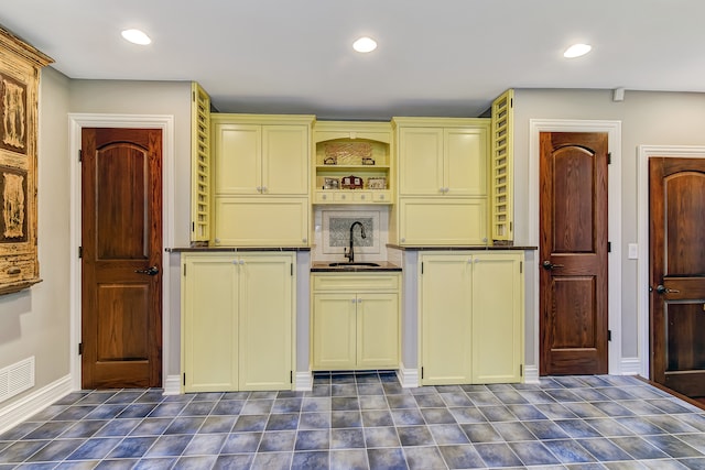 kitchen featuring dark tile flooring and sink