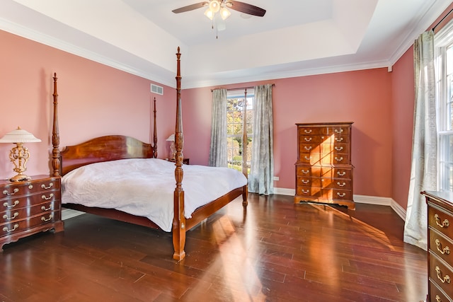 bedroom featuring a raised ceiling, crown molding, dark hardwood / wood-style flooring, and ceiling fan