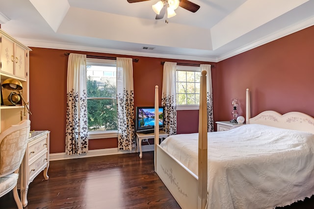 bedroom featuring ceiling fan, crown molding, dark wood-type flooring, and a raised ceiling