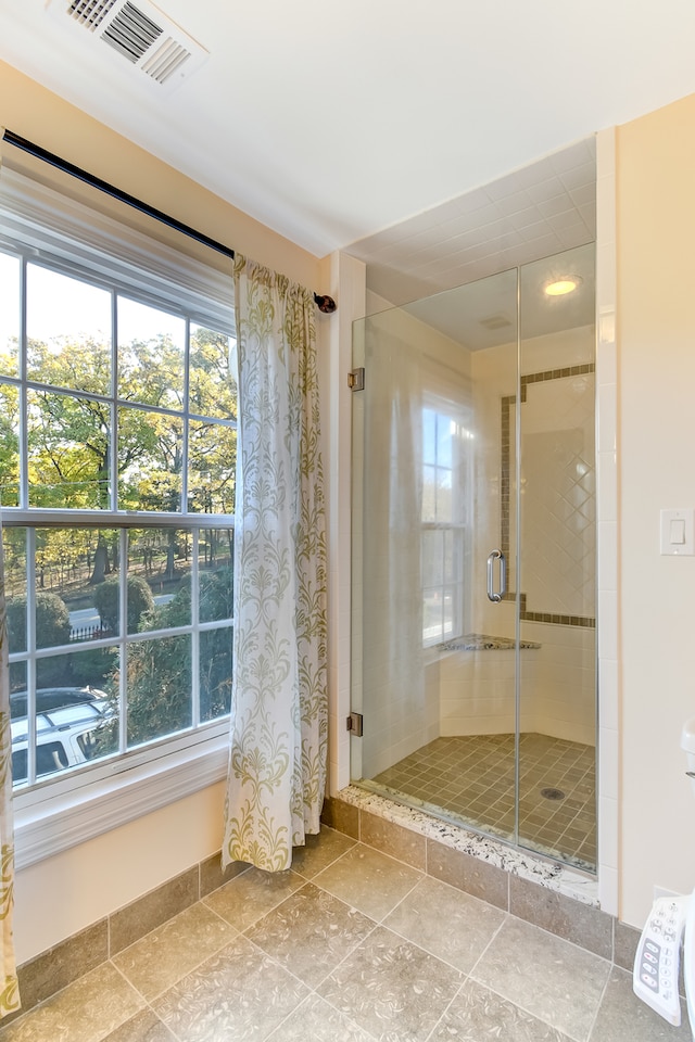 bathroom with tile flooring and a shower with shower door