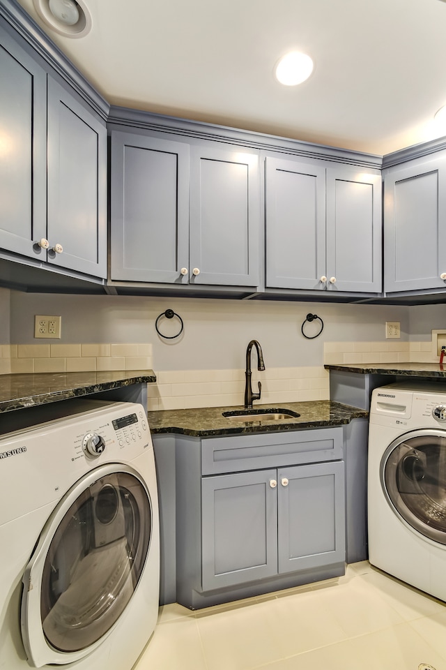 laundry room with cabinets, light tile flooring, sink, and washing machine and dryer