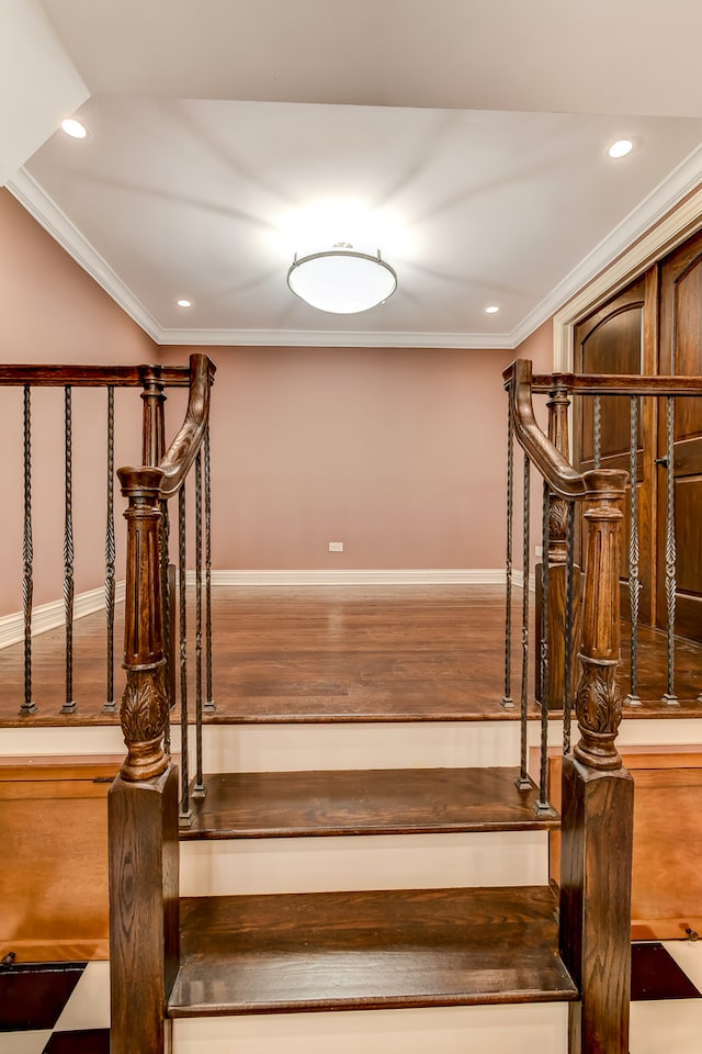 stairs with crown molding and hardwood / wood-style flooring