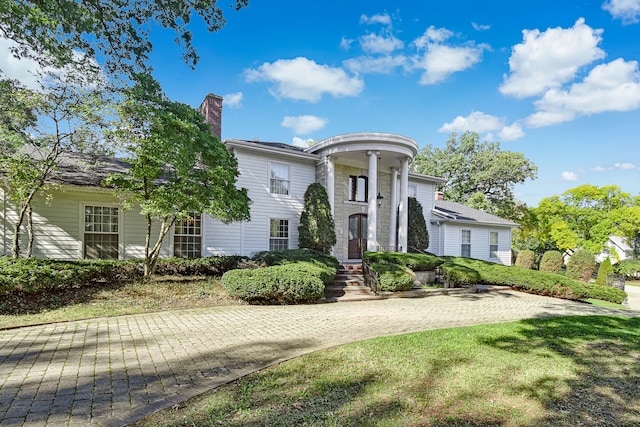 neoclassical home with a front lawn