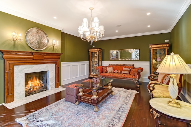 living room featuring crown molding, dark hardwood / wood-style flooring, a fireplace, and a chandelier