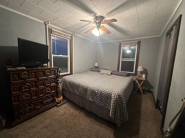 bedroom with ceiling fan, crown molding, and carpet floors