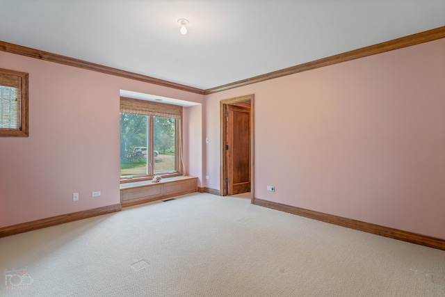 empty room with ornamental molding and light carpet