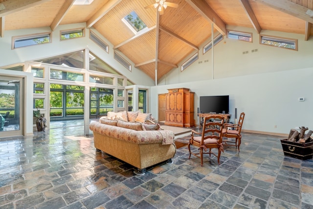 tiled living room featuring a skylight, ceiling fan, beamed ceiling, high vaulted ceiling, and wood ceiling