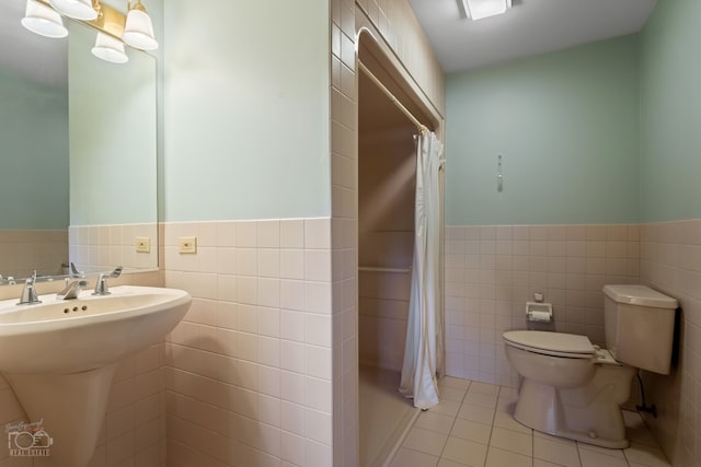 bathroom with tile floors, backsplash, toilet, and tile walls