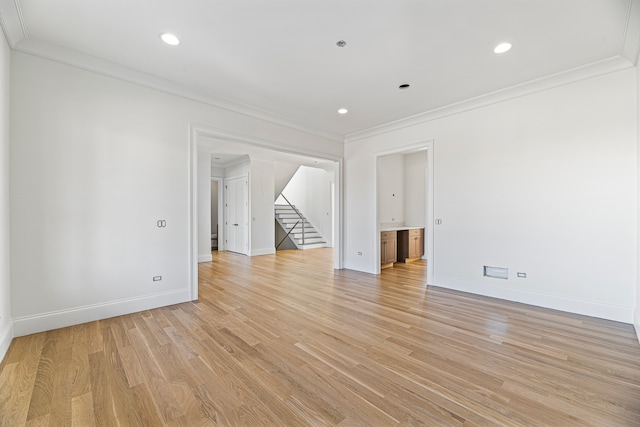 empty room featuring light hardwood / wood-style floors and crown molding