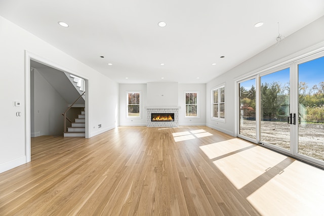 unfurnished living room featuring a wealth of natural light and light hardwood / wood-style floors