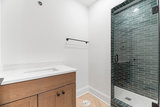 bathroom featuring walk in shower, vanity, and hardwood / wood-style flooring