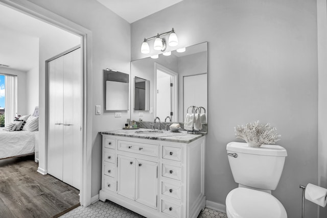 bathroom featuring toilet, vanity, and hardwood / wood-style flooring