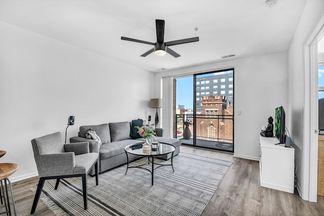 living room featuring light hardwood / wood-style floors and ceiling fan