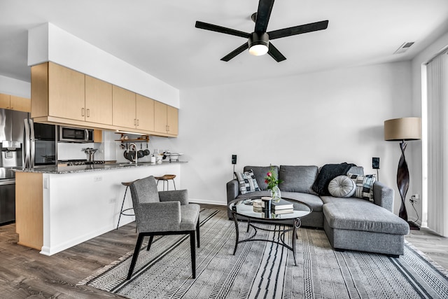 living room with ceiling fan and dark wood-type flooring