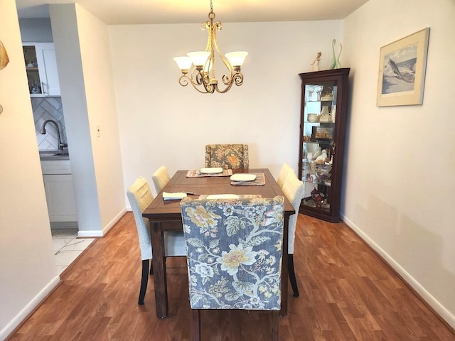 dining room with baseboards, wood finished floors, and a chandelier