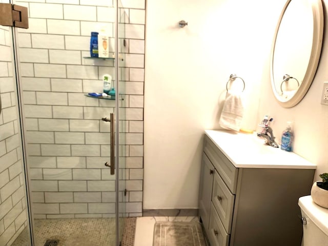 bathroom featuring vanity, tile patterned flooring, a stall shower, and toilet