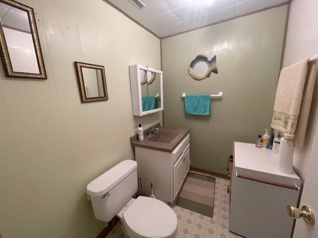 bathroom featuring toilet, tile flooring, and vanity