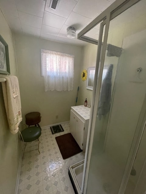 bathroom featuring walk in shower and tile floors