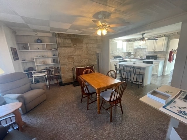 dining room with a fireplace and ceiling fan