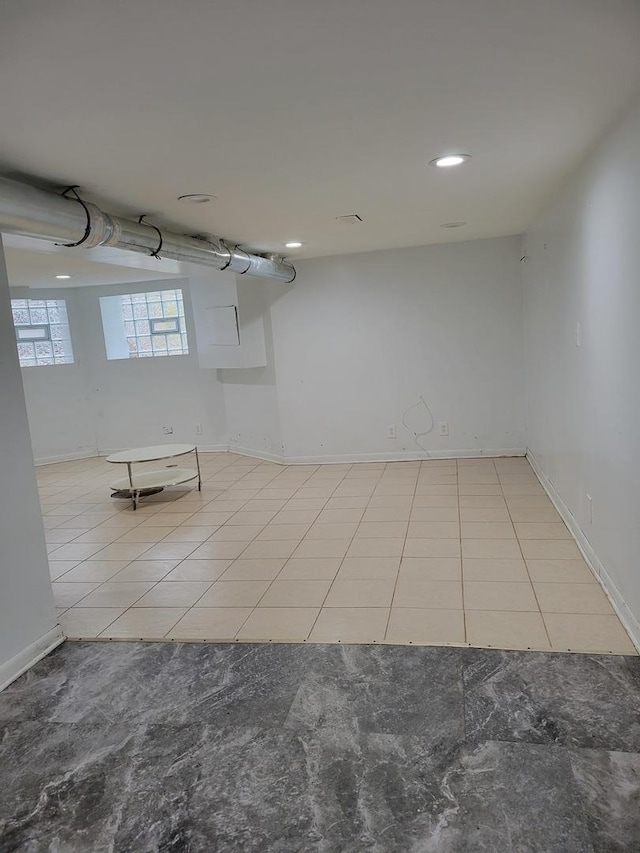 below grade area with recessed lighting, baseboards, and light tile patterned floors