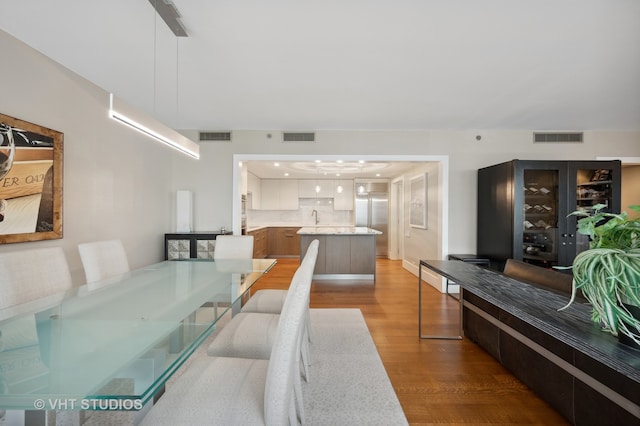 dining area with sink and hardwood / wood-style flooring